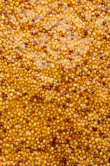 French Dijon mustard in a metal spoon, top view on mustard grains background. Gastronomy concept,...