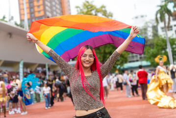 Young beautiful asian lesbian with pride movement LGBT holding rainbow flag raise up for freedom....