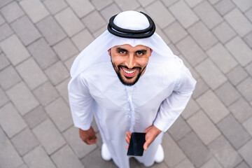 Arab middle-eastern man wearing emirati kandora traditional clothing in the city