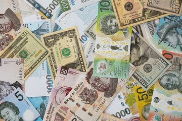 Big amount of money bills of different currencies and countries. Assortment background of international cash in big pile close up
