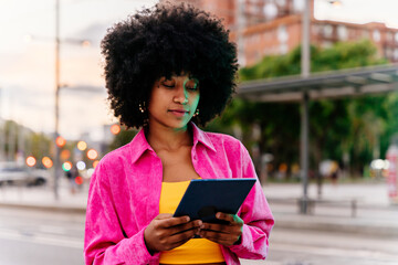 Beautiful young happy african woman with afro curly hairstyle strolling in the city - Cheerful black student girl walking on the street