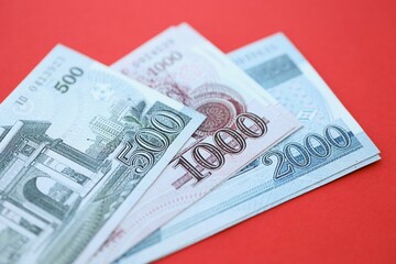 North Korean won money bills in big amount lies on red color table close up