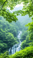 Lush green foliage frames a cascading waterfall amidst misty mountains