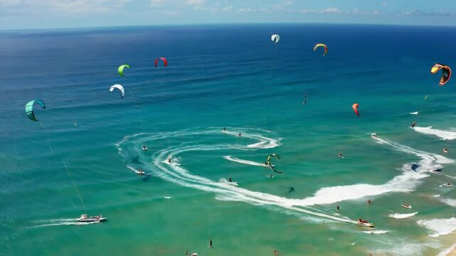 Aerial view of kitesurfing activity on turquoise ocean.
