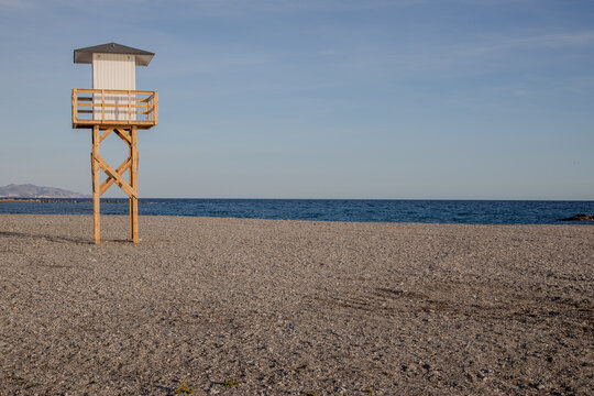 Minimalist Lifeguard Tower on Empty Pebble Beach at Sunrise

