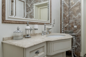 elegant bathroom in retro style. chrome faucet, large sink, mirror in frame. brown, white and beige ceramic tiles on walls. Bathroom design in luxury housing. 