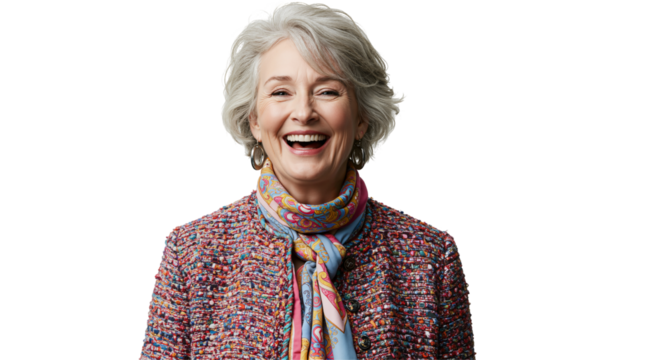 An older white woman with short grey hair smiles and laughs brightly while wearing a colorful tweed jacket and a patterned scarf against a transparent background.