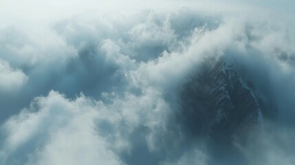 Obraz premium Majestic mountain peak surrounded by dense storm clouds du a turbulent weather scene in a high-altitude environment with dramatic sky and natural landscape