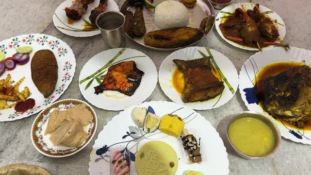 Traditional Bengali food platter for rice ceremony which includes rice, fish, mutton, curd, rosogolla.