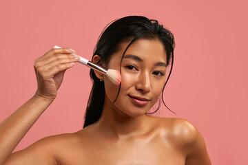 Young Asian woman on pastel pink background.