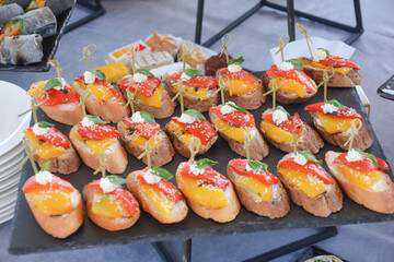 Buffet food for party decorated with fresh plants. Sandwiches with cheese and ham on table.  Catering buffet food indoor in luxury restaurant with meat and vegetables. Buffet table with delicacies