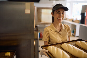 Happy female baker at work looking at camera.