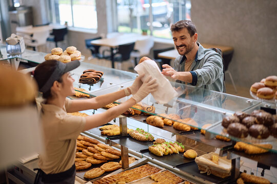 Happy man buying pastry in bakery.