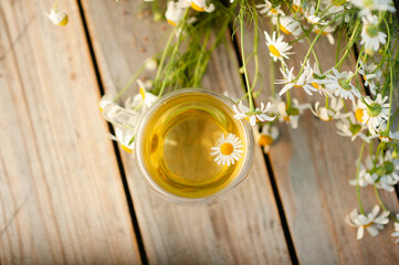 Summer herbal tea with chamomile in a glass that does not burn your hands.