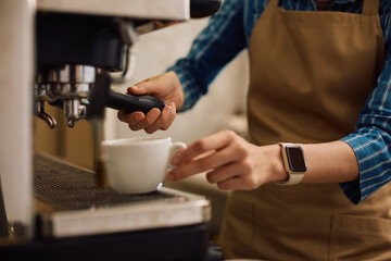 Close up of waitress making coffee in cafe.
