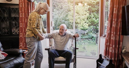 Senior, couple and help with walking stick for care, support or assistance on sofa in living room of home. Elderly, woman or man with disability or cane in lounge of retirement with love and recovery