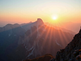 Fototapeta premium Lever de soleil sur des montagnes majestueuses avec ciel clair et pics escarpés
