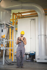 Young maintenance technician checking machines in factory