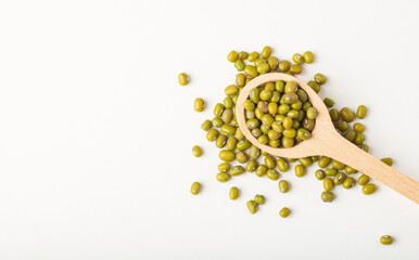 Raw mung beans or dal in  wooden spoon on white background isolated, top view with copy space