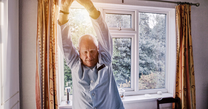 Senior man stretching arms in home bedroom, relax or body health in the morning. Elderly person wake up for wellness, comfort and awake to start fresh day in pajamas in retirement, apartment or house - Powered by Adobe