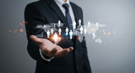 A businessman in a suit holding a digital world map with people icons over his hand in a gray background