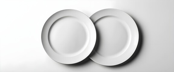 Two Overlapping White Oval Plates on White Background