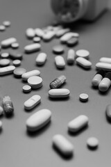 Monochrome Pill Bottle & Scattered Tablets on Dark Background