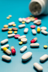 Colorful Pills and Capsules on Blue Background, Top-Down View