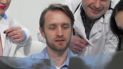 Focused medical team analyzing x-ray or MRI scan together - Powered by Adobe