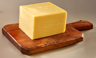 Butterkaese Stueck auf rustikalem Holzbrett, Käse, Käsestück, Käseblock, 