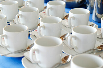 Coffee cup on table with coffee pouring from jar
