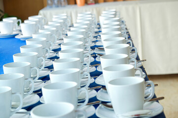 Coffee cup on table with coffee pouring from jar