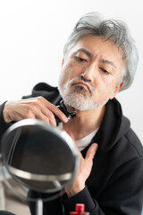 身だしなみを整えるシニア男性