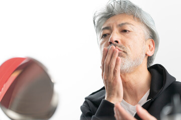 身だしなみを整えるシニア男性