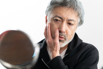 身だしなみを整えるシニア男性