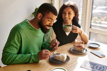 Couple enjoying dessert over coffee in a cozy cafe during a sunny afternoon