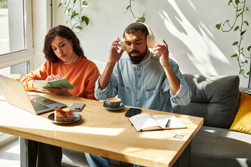 Couple collaborating on freelance projects in a cozy cafe setting