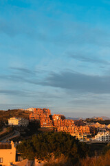Obraz premium Hillside residential area at sunset with orange tones on buildings in Calahonda, Costa del Sol, Spain