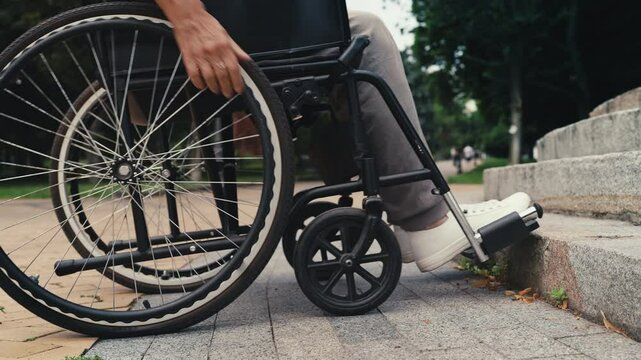 Wheelchair user stops near staircase, facing accessibility infrastructure issue