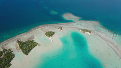 Aerial drone of breathtaking Rangiroa atoll in French Polynesia, vibrant turquoise water lagoon and blue deep ocean, pristine white sandbars beach, small tropical islands with palm trees motu