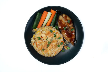 Garlic fried rice with fried mackerel in teriyaki sauce, carrots and cucumber on white background isolated. Top view.