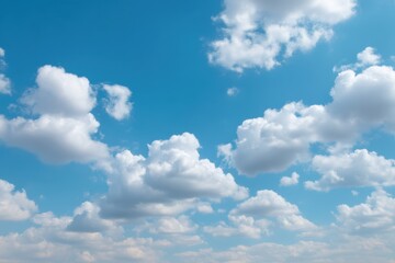 Obraz premium Fluffy White Clouds Drifting Across a Vivid Blue Sky: A Serene Daytime View of Nature's Beauty