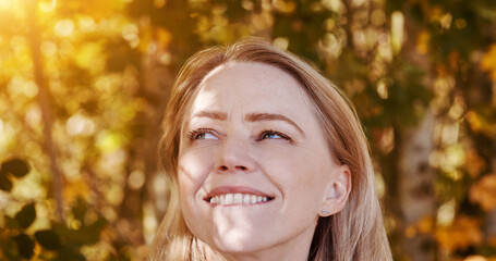 Face, thinking and a happy woman in autumn garden for freedom, peace or inspiration from nature. Idea, smile and relax with a young person at a park in the afternoon during the colorful fall season