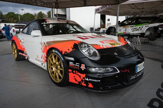 spectacular Porsche 911 997 GT3 Cup 3.6 rally car with its large spoiler and golden wheels.