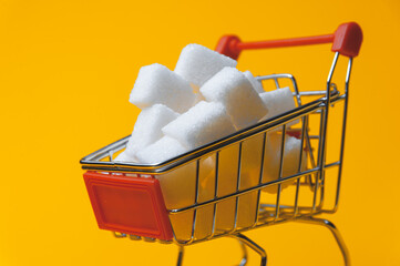 Small cart with sugar on a yellow background. Visualization of sugar value