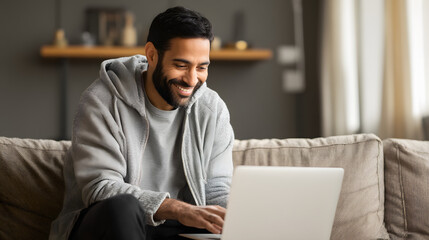 Hispanic man working from home on his laptop, young adult smiling and having a business call