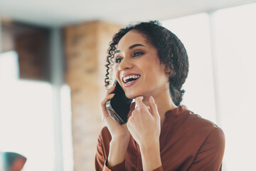 Smiling businesswoman engaging in a phone call while working in a modern well-lit office environment