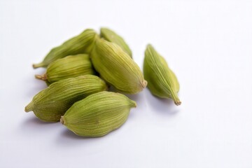 Whole green cardamom pods on white background, aromatic spice closeup
