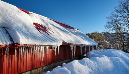 thick snow on red metal roof melting under sun creating risk of collapse and falling icicles