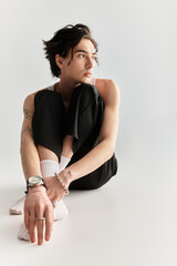 Trendy young man poses stylishly in a sleek studio setting